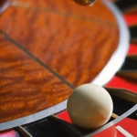 Игровое колесо рулетки в казино с шариком и ставками на столе